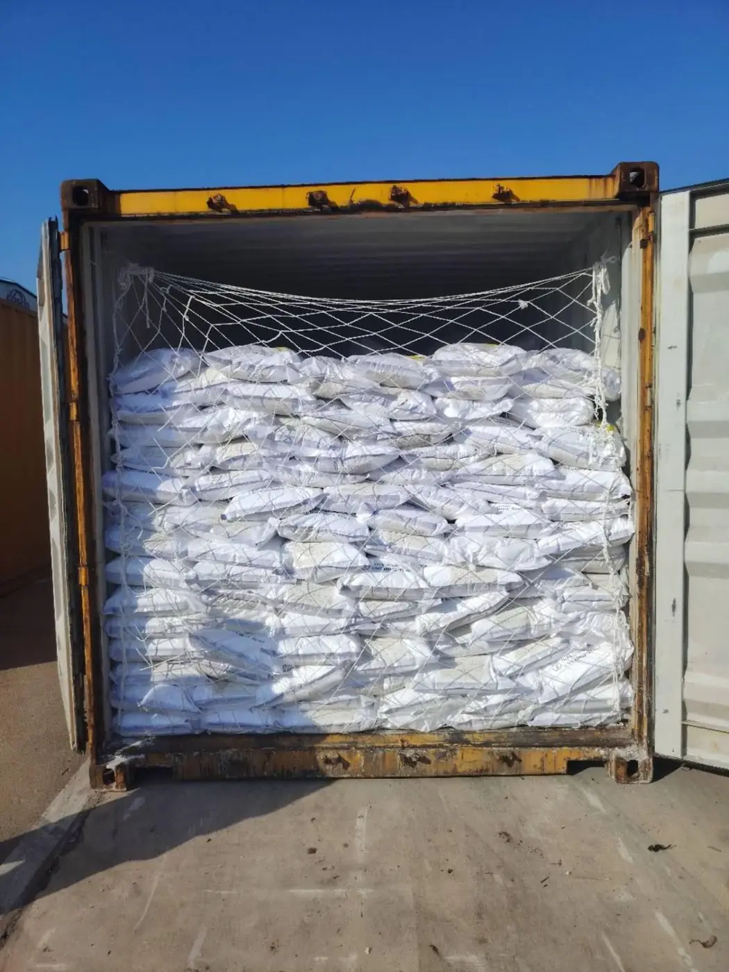 Container fully loaded with netted 25 kg bags