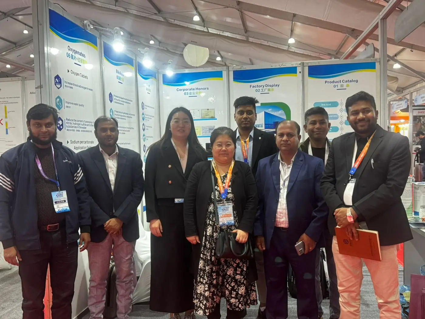 Team at an international trade fair booth showing oxygenates product wall