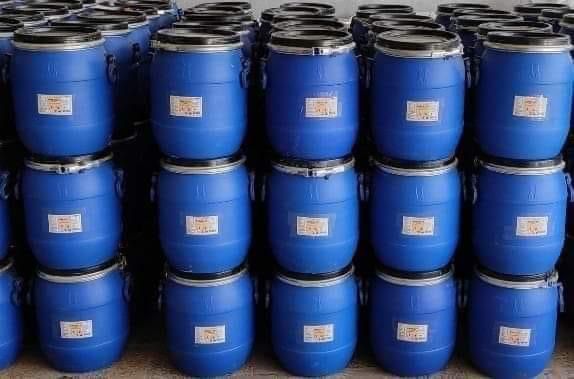 Blue drums of imported raw material stacked in warehouse